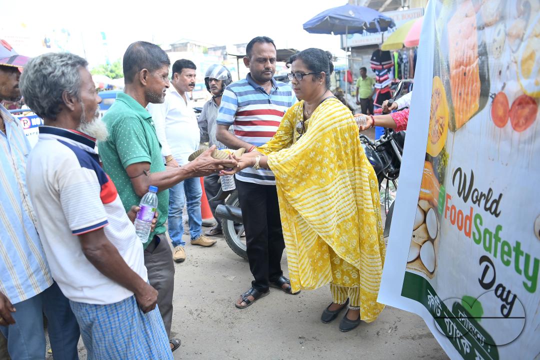 People get food from a social worker on World Food Safety Day, organised by Rotary Club of Agartala, in Agartala