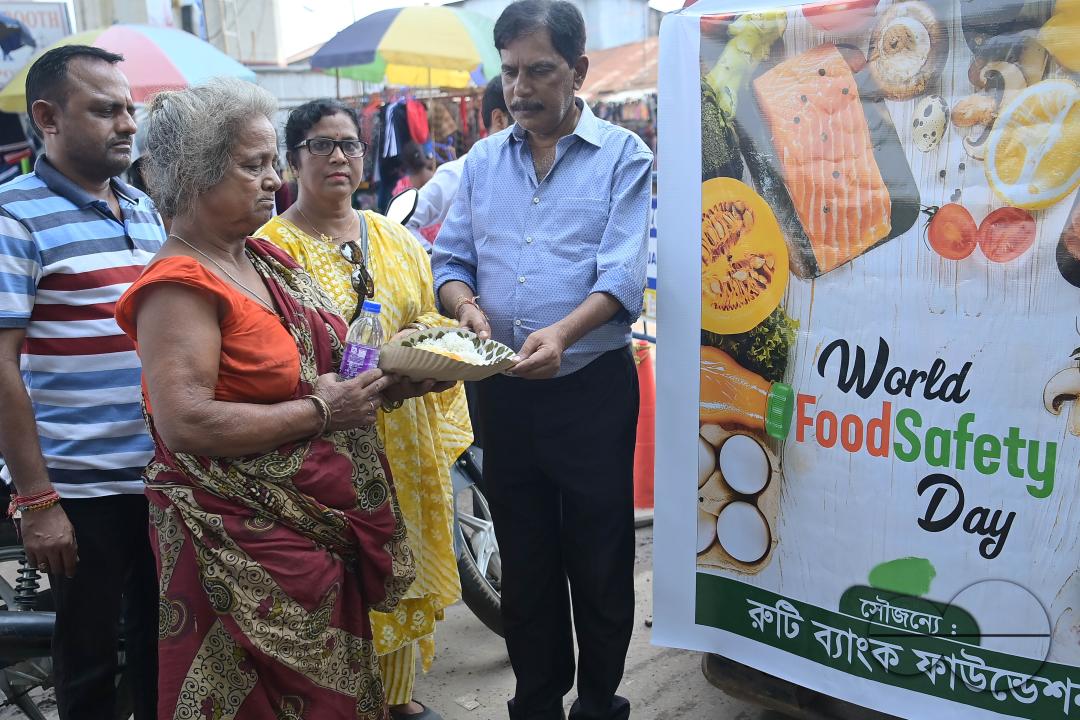 People get food from a social worker on World Food Safety Day, organised by Rotary Club of Agartala, in Agartala