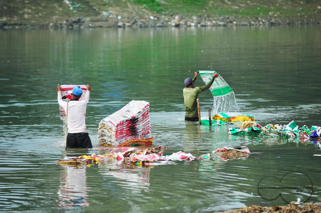 Women are risking their lives to wash cement bags beside the Surma River in Sylhet