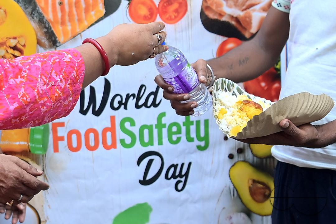 People get food from a social worker on World Food Safety Day, organised by "Roti Bank Foundation", in Agartala