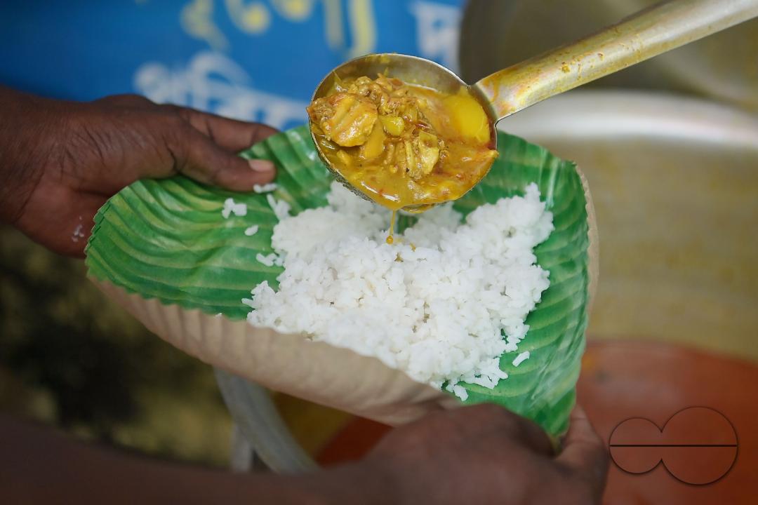 People get food from a social worker on World Food Safety Day, organised by "Roti Bank Foundation", in Agartala