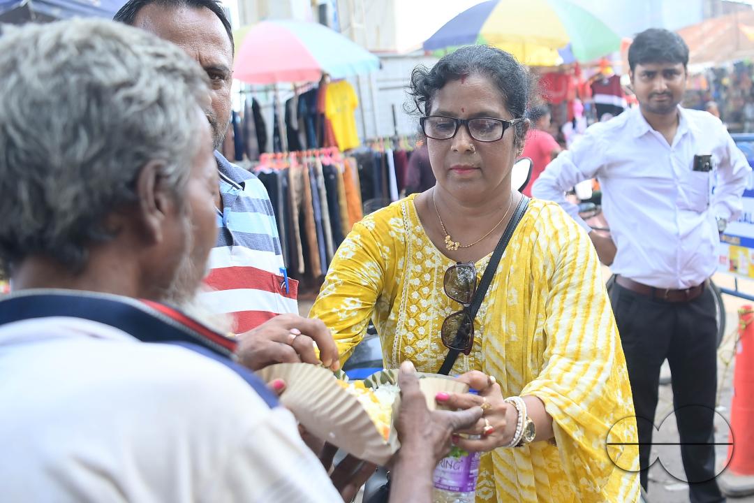 People get food from a social worker on World Food Safety Day, organised by "Roti Bank Foundation", in Agartala