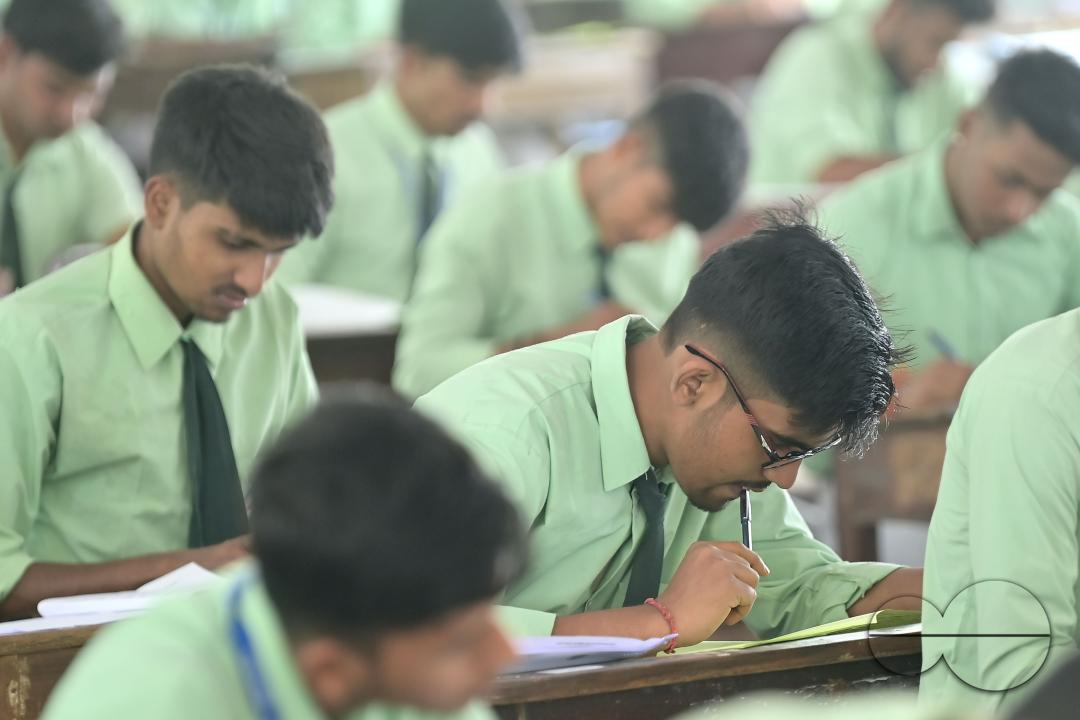 Students are seen writing an English paper