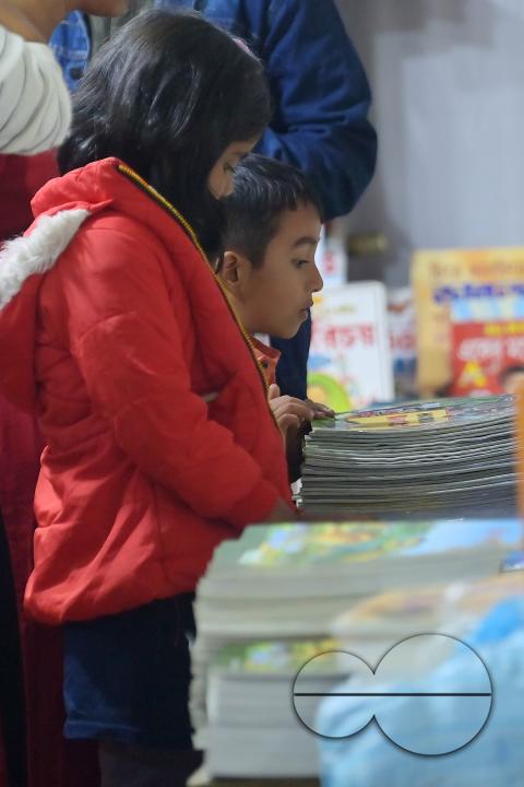 Children looking at books in a book stall at the 42nd Agartala Book fair International Fair Ground, Hapania at Agartala