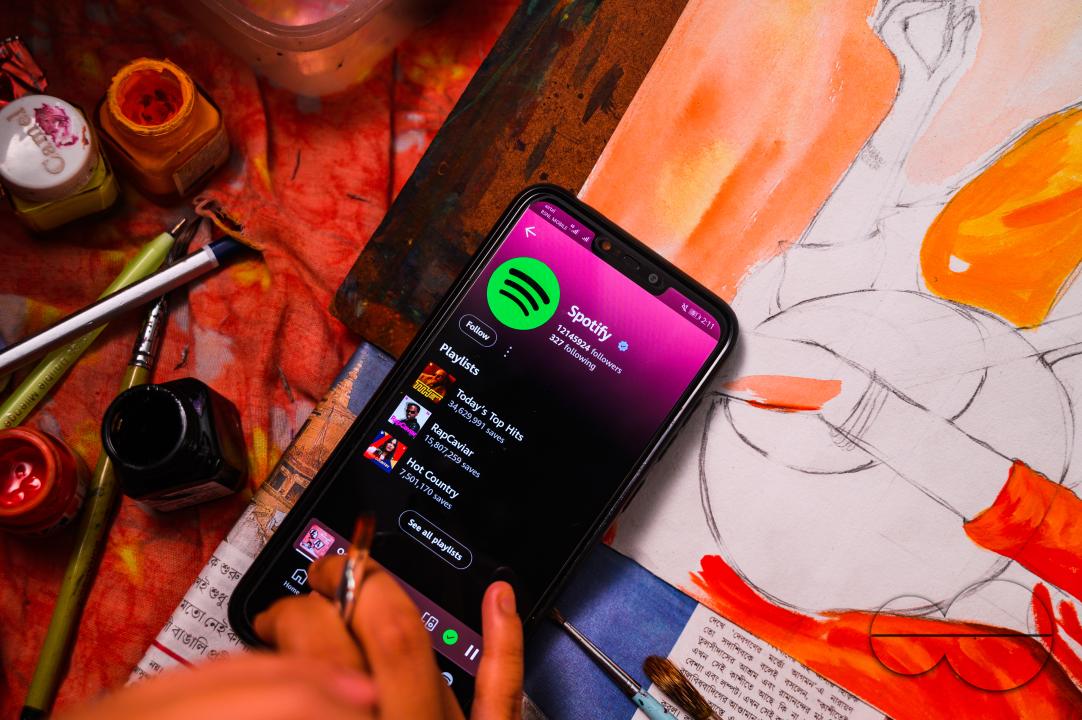 A girl draws a picture of "Mirabai" (16th-century Hindu mystic poet and devotee of Krishna), while listening to music on the Spotify app
