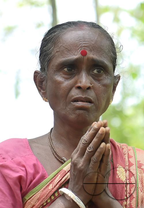 An elderly woman is crying in front of local MLAS officials at her makeshift tent at the Panisagar's reserve forest