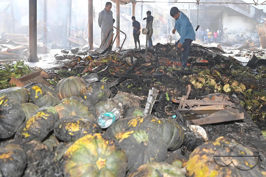 Shop owners and vendors are seen in front of their burnt shops and vegetables stalls in Battala market, the second biggest market in Tripura
