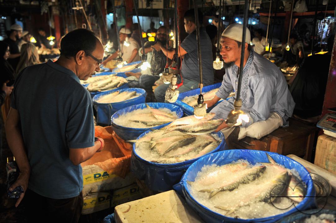 People buy Hilsa fish at the Lalbazar fish market in Sylhet city