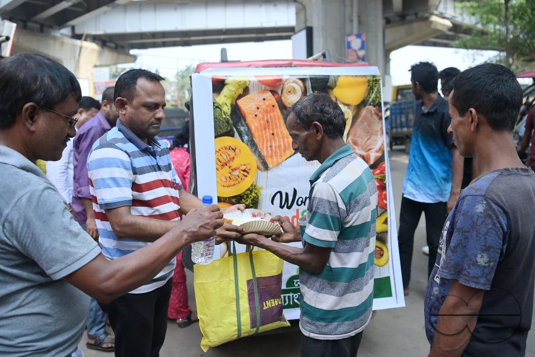 People get food from a social worker on World Food Safety Day, organised by "Roti Bank Foundation", in Agartala