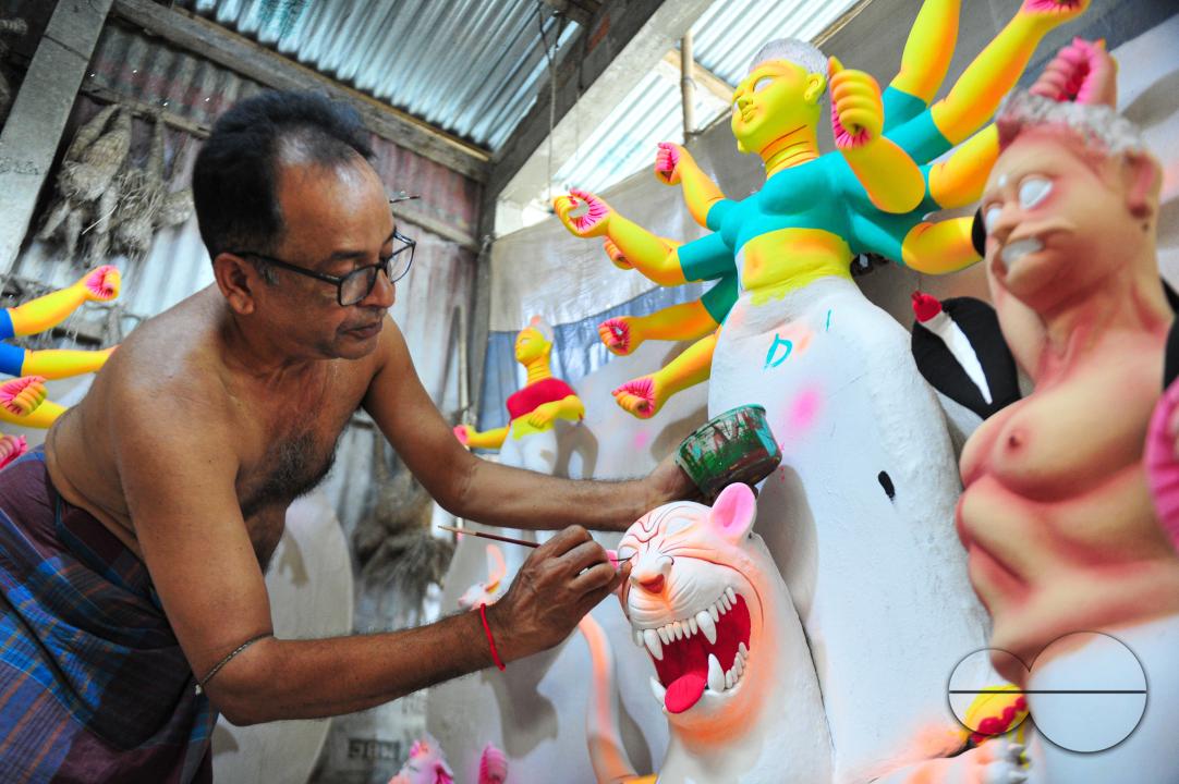 Dulal Paul, a veteran Idol Artist is colouring structures of a Hindu Deity in preparation for the upcoming Durga Puja Festival