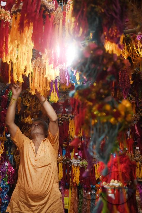 A shop owner arranging "Rakhi", sacred threads for the upcoming "Raksha Bandhan" festival at his shop in Agartala