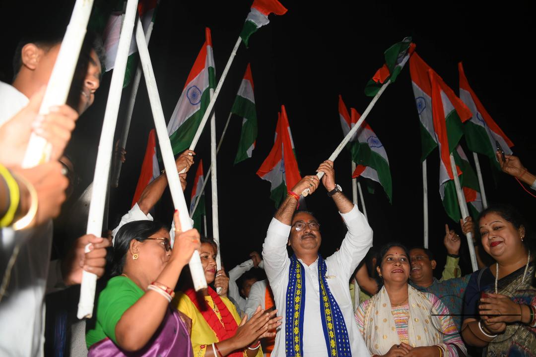 BJP party leaders, workers and the general public celebrate with the Indian flag in front of a LCD TV during the live stream of the successful lunar landing of the Chandrayaan-3 spacecraft on the south pole of the Moon, in Agartala