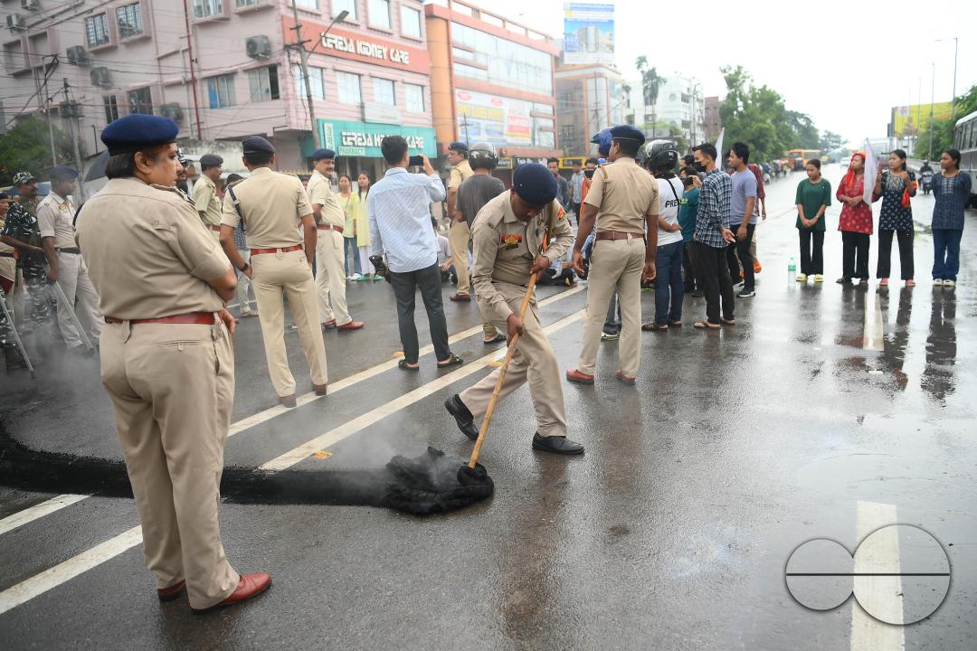 A police officer is trying to control burning tyres during a protest by the supporters of the TSF (Twipra Students Federation) are protesting and demanding the introduction of Kokborok in Roman Script and passage of the 125th Constitutional Amendment Bil
