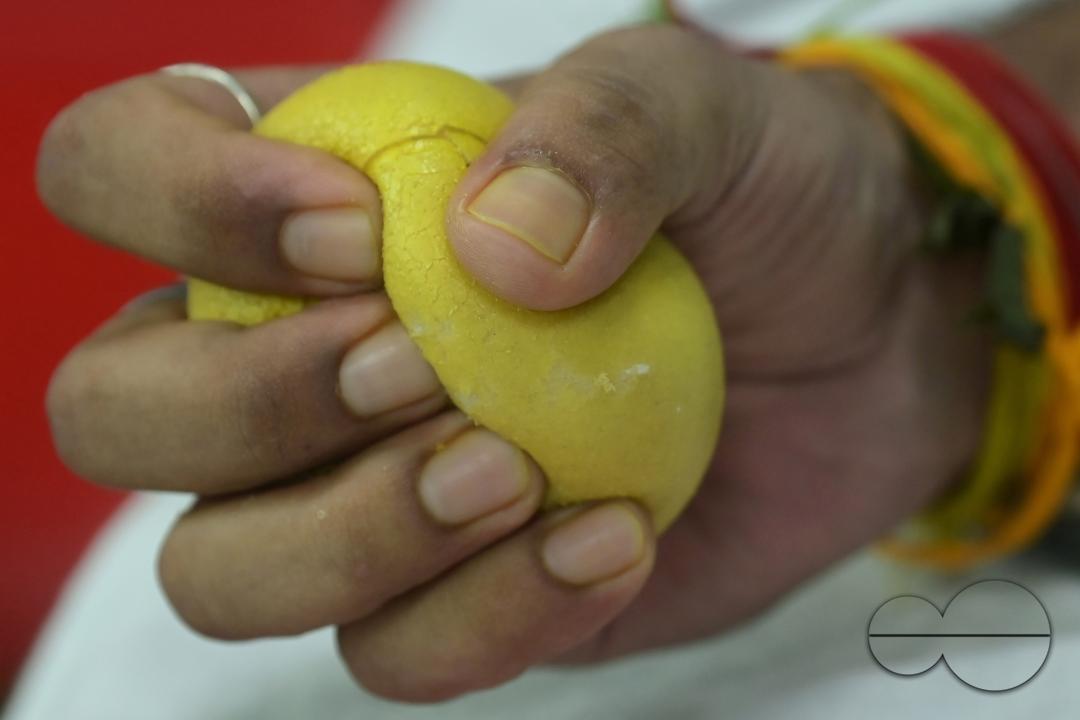 A man squeezes a sponge ball as he donates blood on World Blood Donor Day at a blood donation centre in Agartala