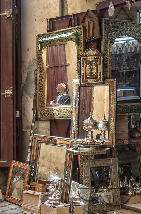 Reflection of a trader in the mirror of a shop in the medina of Fez