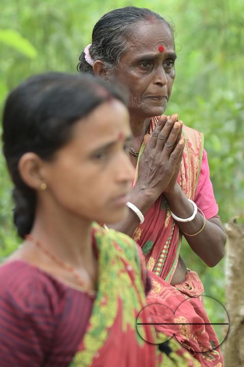 An elderly woman is crying in front of local MLAS officials at her makeshift tent at the Panisagar's reserve forest