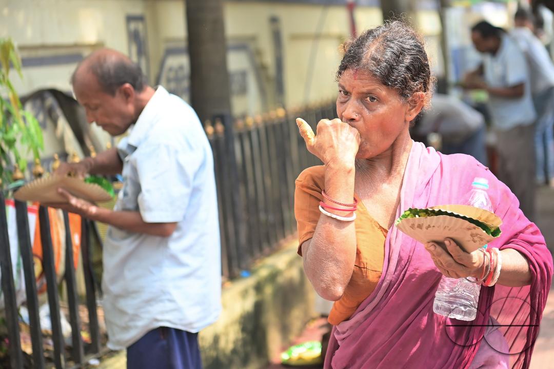 People eating food distributed by a social worker on World Food Safety Day organised by "Roti Bak Foundation", in Agartala