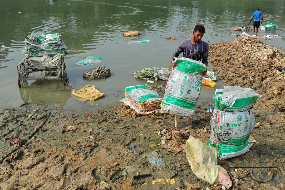 Women are risking their lives to wash cement bags beside the Surma River in Sylhet