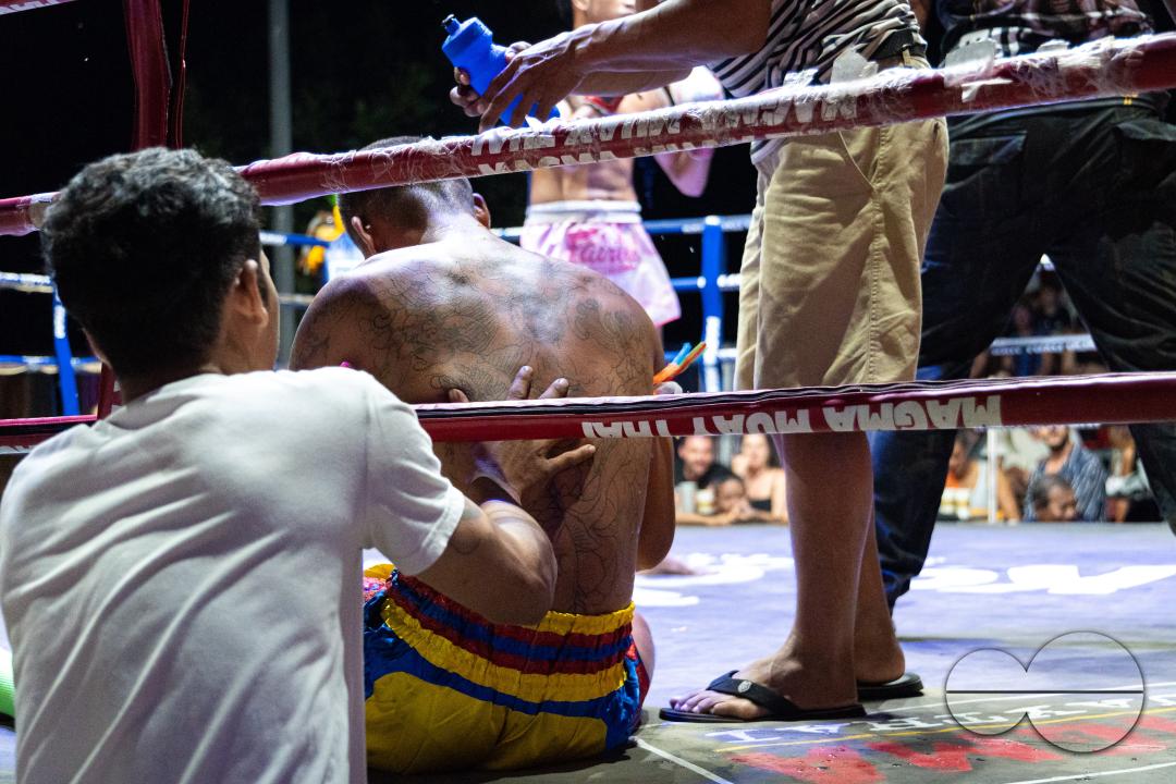 The trainer helps his boxer, Petch Si Nel (right), to get up after he was knocked out by his opponent, Frame Payak (not pictured), during the Muay Thai Fights, on Koh Chang Island, Thailand.
