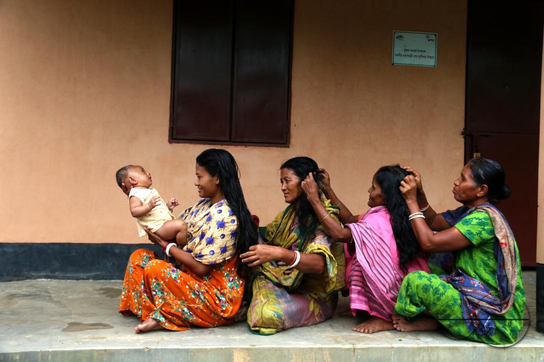 Rural Bangladeshi women use fingers to separate hair and create a part