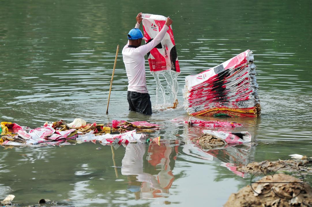 Women are risking their lives to wash cement bags beside the Surma River in Sylhet