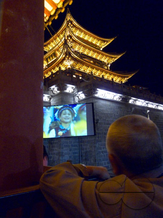 CHINA Elderly man watching a movie at an outdoor screen in Dali, Yunnan province.