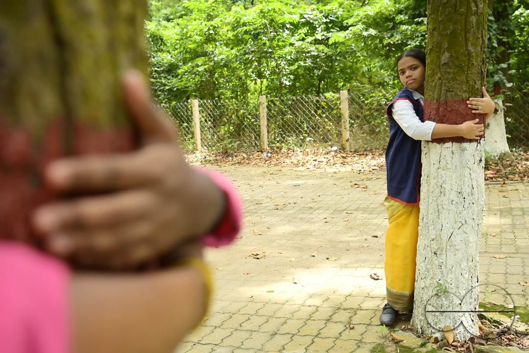 NSS (National Service Scheme) volunteers and school students of Netaji Subhas Vidyaniketan hug trees on the eve of World Nature Conservation Day