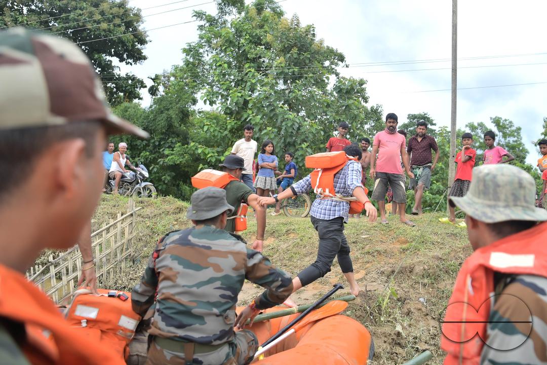 Assam Rifles personnel going to a relief camp through flooded water to distribute food items to flood victims at relief camps of Amarpur city, 82km away from Agartala