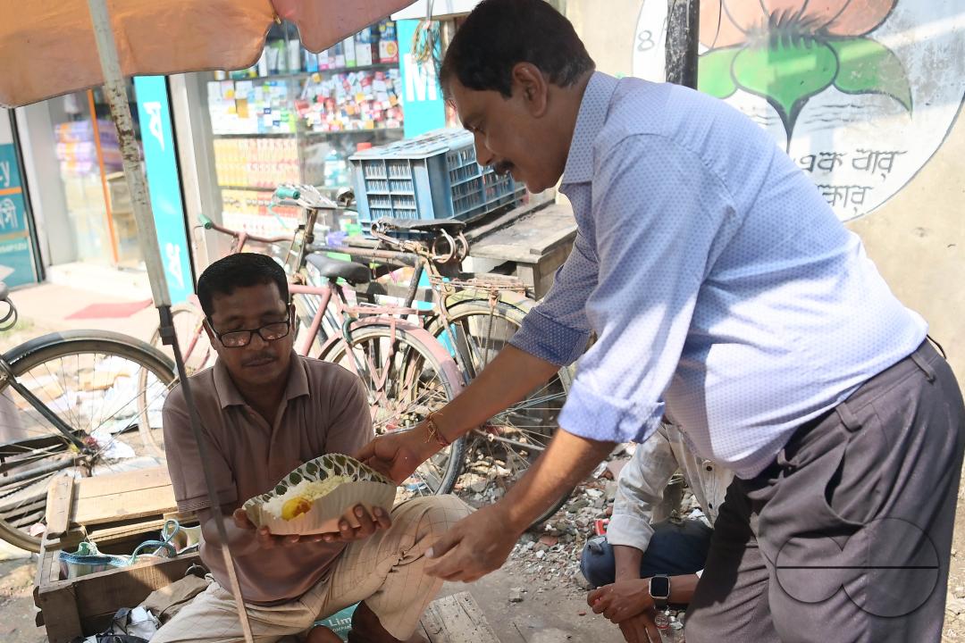 People get food from a social worker on World Food Safety Day, organised by Rotary Club of Agartala, in Agartala