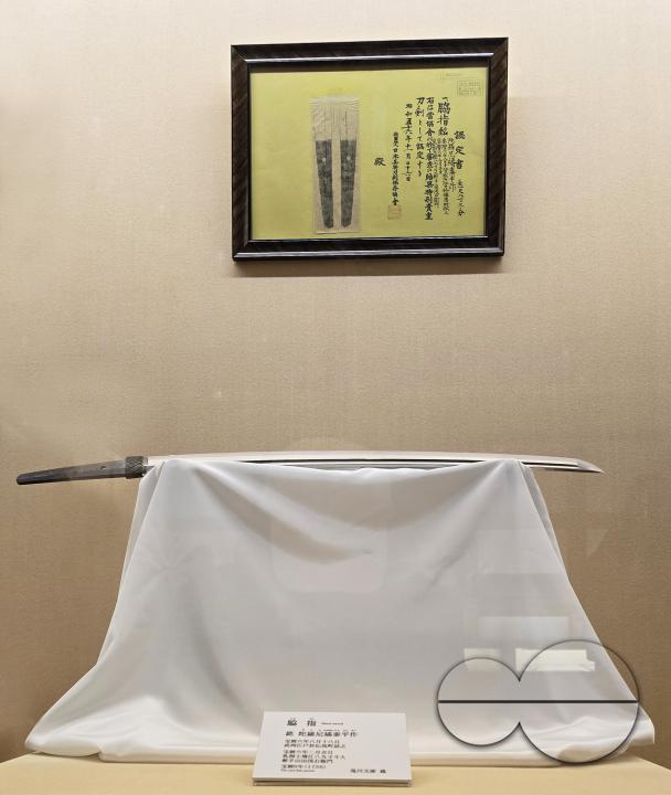 A katana is a Japanese sword characterized by a curved, single-edged blade with a circular or squared guard and long grip to accommodate two hands