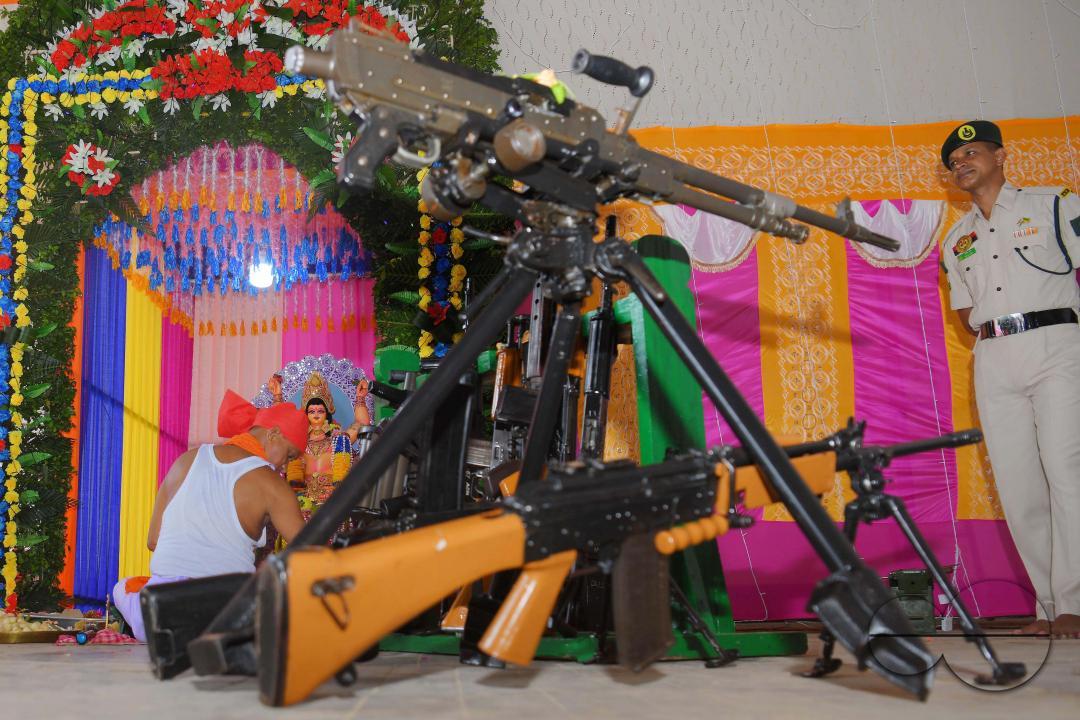 A priest performs worship of arms on Vishwakarma Puja in a TSR (Tripura State Rifles) camp on the outskirts of Agartala