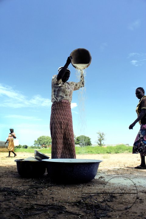 An IDP woman uses a local method to blow-out husks from beans, which is to be sold in market the nex