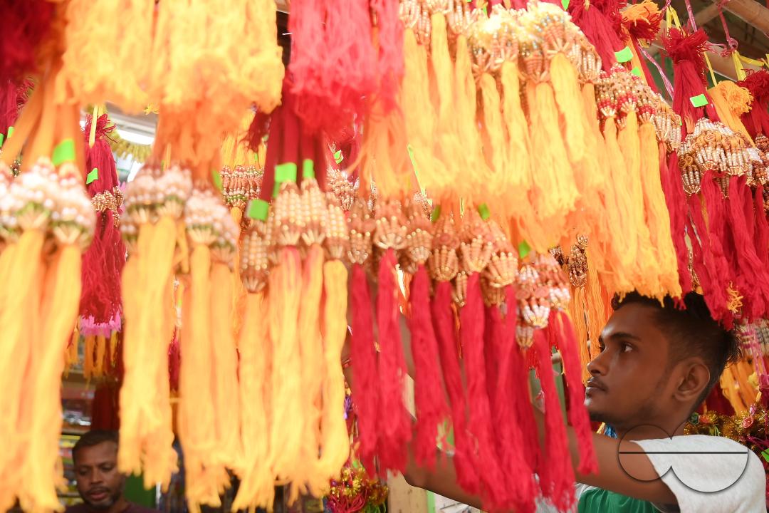 A shop owner arranging "Rakhi", sacred threads for the upcoming "Raksha Bandhan" festival at his shop in Agartala