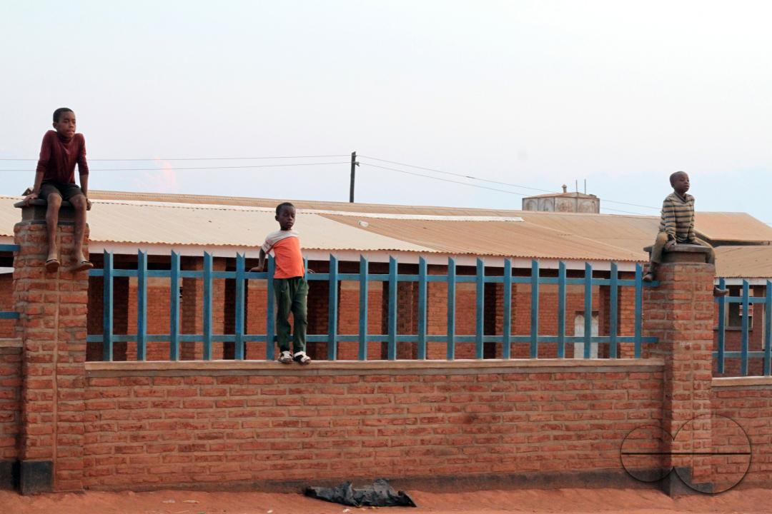 Young boys on a wall to catch a glimpse of a musical performance during a festival at Dzaleka Refugee Camp in Dowa District, Malawi