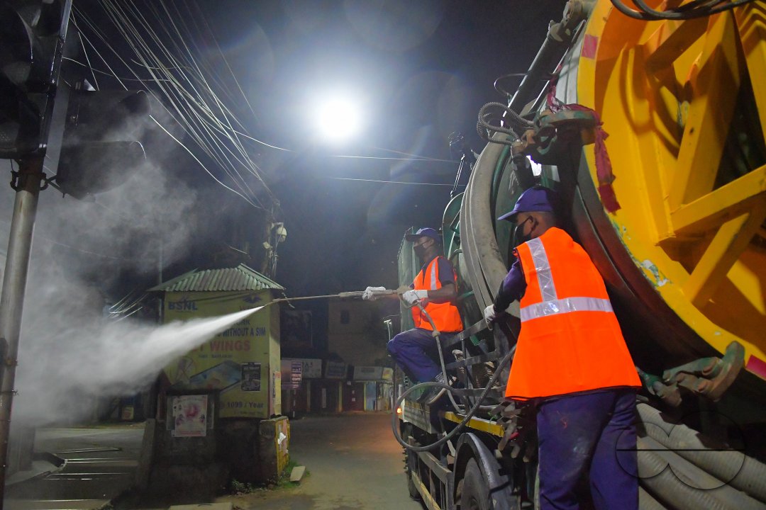 Workers Spray Disinfectant to Contain Coronavirus