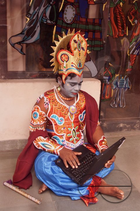 A South Indian dancer works with his laptop before a stage show at a dance festival in Kolkata