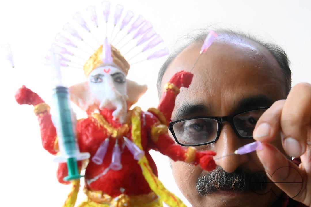Samiran De, an artist works on an idol of Lord Ganesha made with soup and syringe needles to alert people against drugs, ahead of Ganesh Chaturthi festival, in Agartala