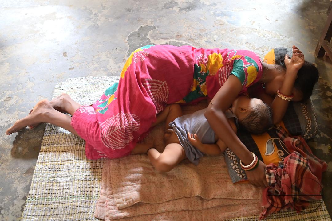 A mother is sleeping with her kid at a temporary relief camp at Pratapgarh English Medium School in Agartala