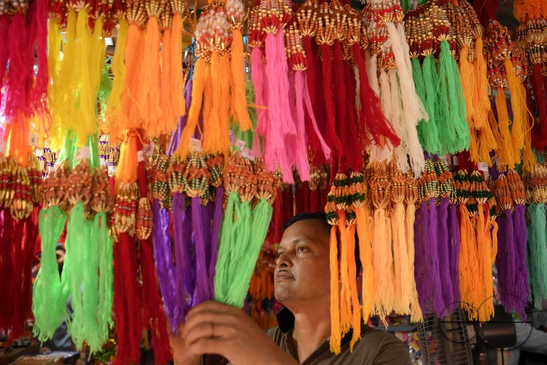 A shop owner arranging "Rakhi", sacred threads for the upcoming "Raksha Bandhan" festival at his shop in Agartala