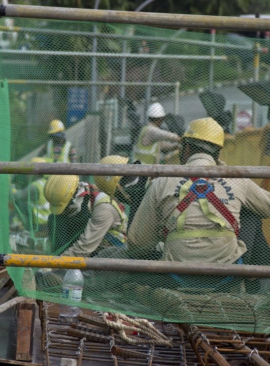 Migrant workers at a construction site by a highway in Singapore