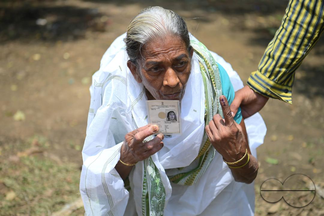 An elderly woman proudly displays her inked finger after voting at the Lok Sabha elections at a Boxanagar polling station in Agartala
