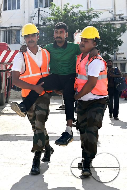 Fire brigade personnel are trying to control a fire on the top of the building of the dental college during a state level mock exercise on earthquake day at Agartala