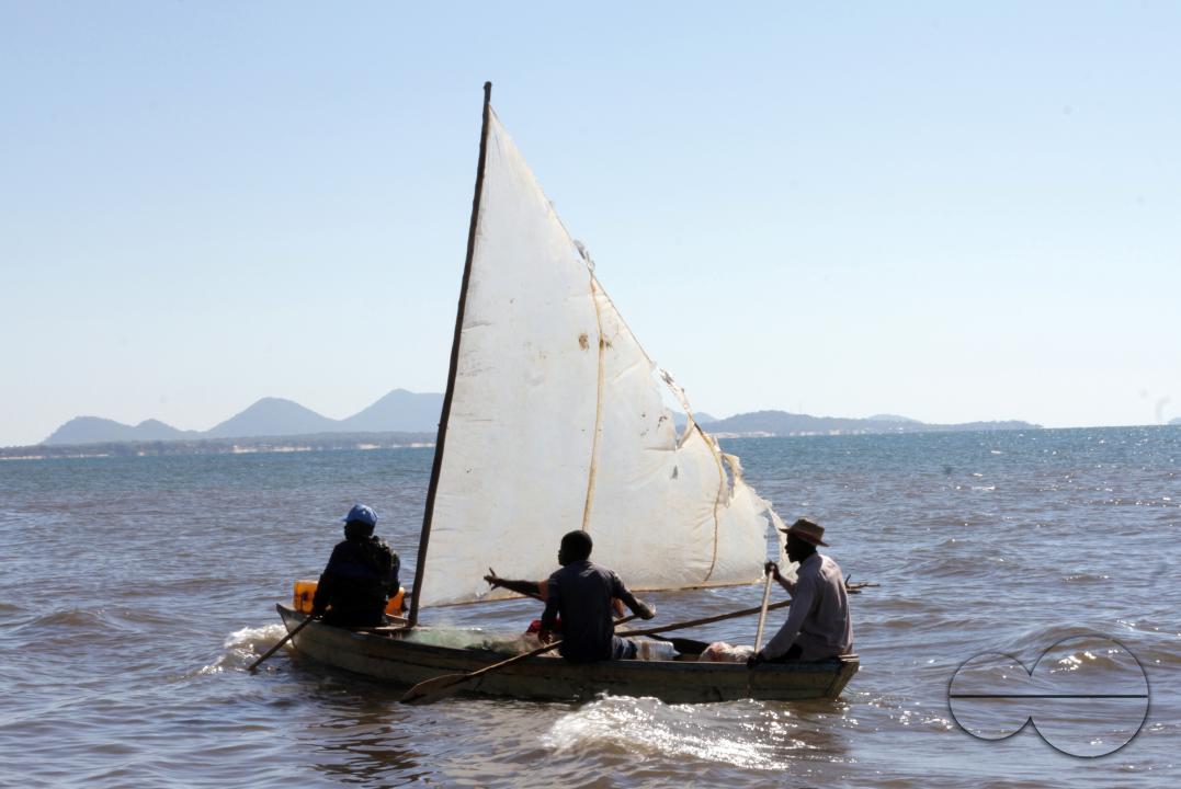 Three fisherman on Lake Malawi in their plastic-powered fishing boat