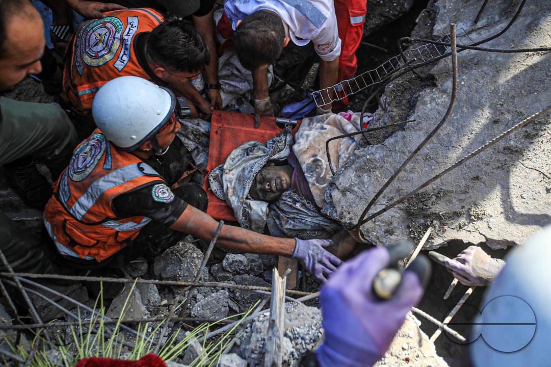 The Palestinian Civil Defense is trying to get a Palestinian woman out of the rubble of his house, which was destroyed by Israeli planes in Khanounes, southern Gaza Strip