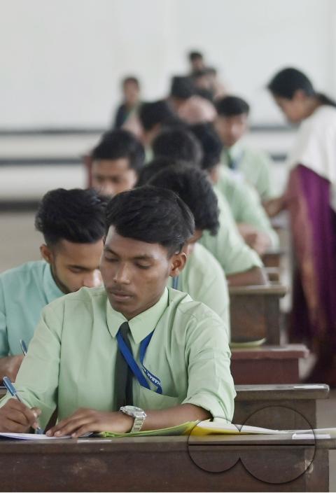 Students are seen writing an English paper