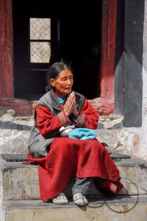 A woman praying outside in the Thiksey Monastery, Ladakh.