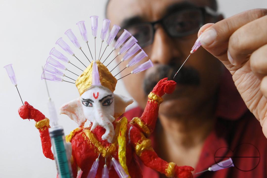 Samiran De, an artist works on an idol of Lord Ganesha made with soup and syringe needles to alert people against drugs, ahead of Ganesh Chaturthi festival, in Agartala
