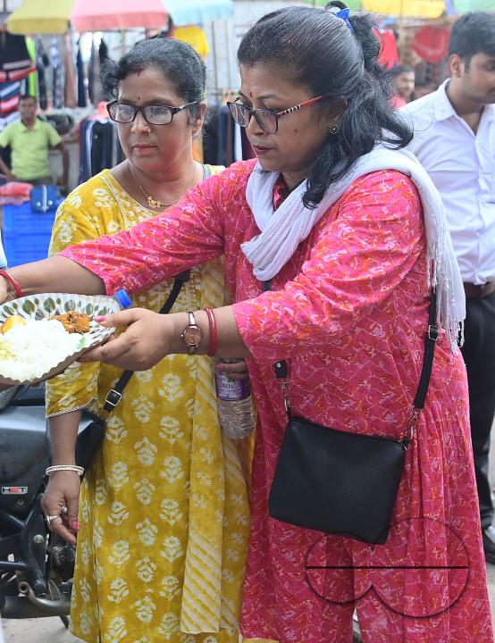 People get food from a social worker on World Food Safety Day, organised by "Roti Bank Foundation", in Agartala