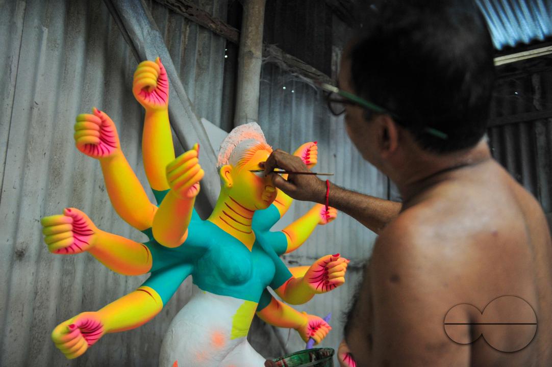 Dulal Paul, a veteran Idol Artist is colouring structures of a Hindu Deity in preparation for the upcoming Durga Puja Festival