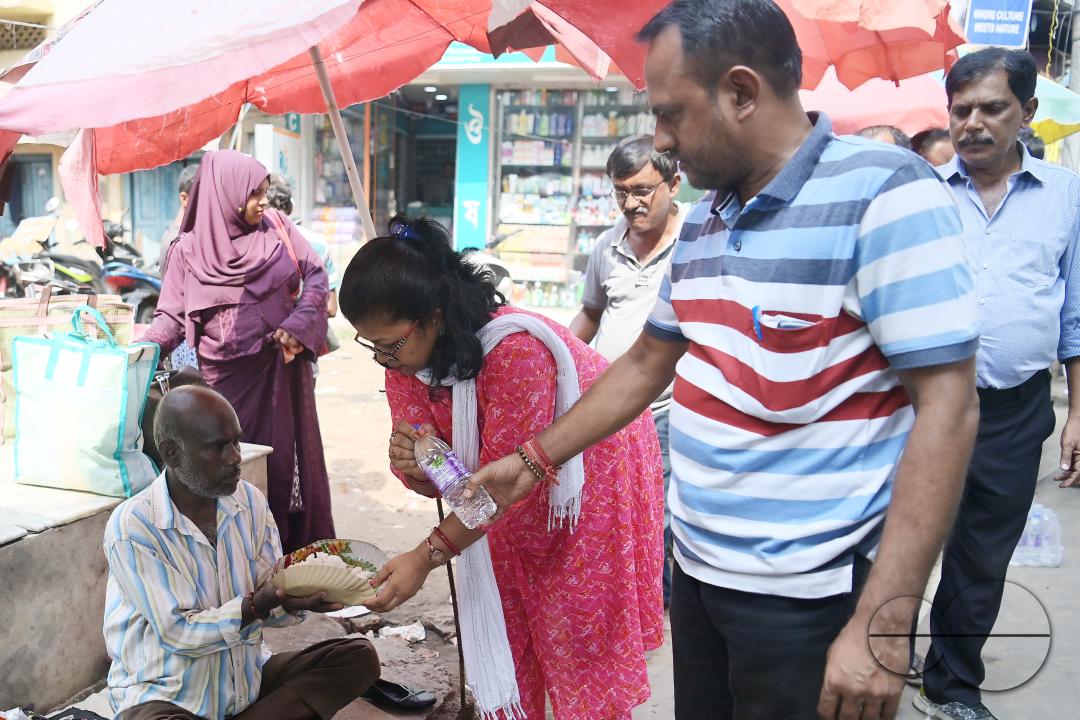 People get food from a social worker on World Food Safety Day, organised by "Roti Bank Foundation", in Agartala